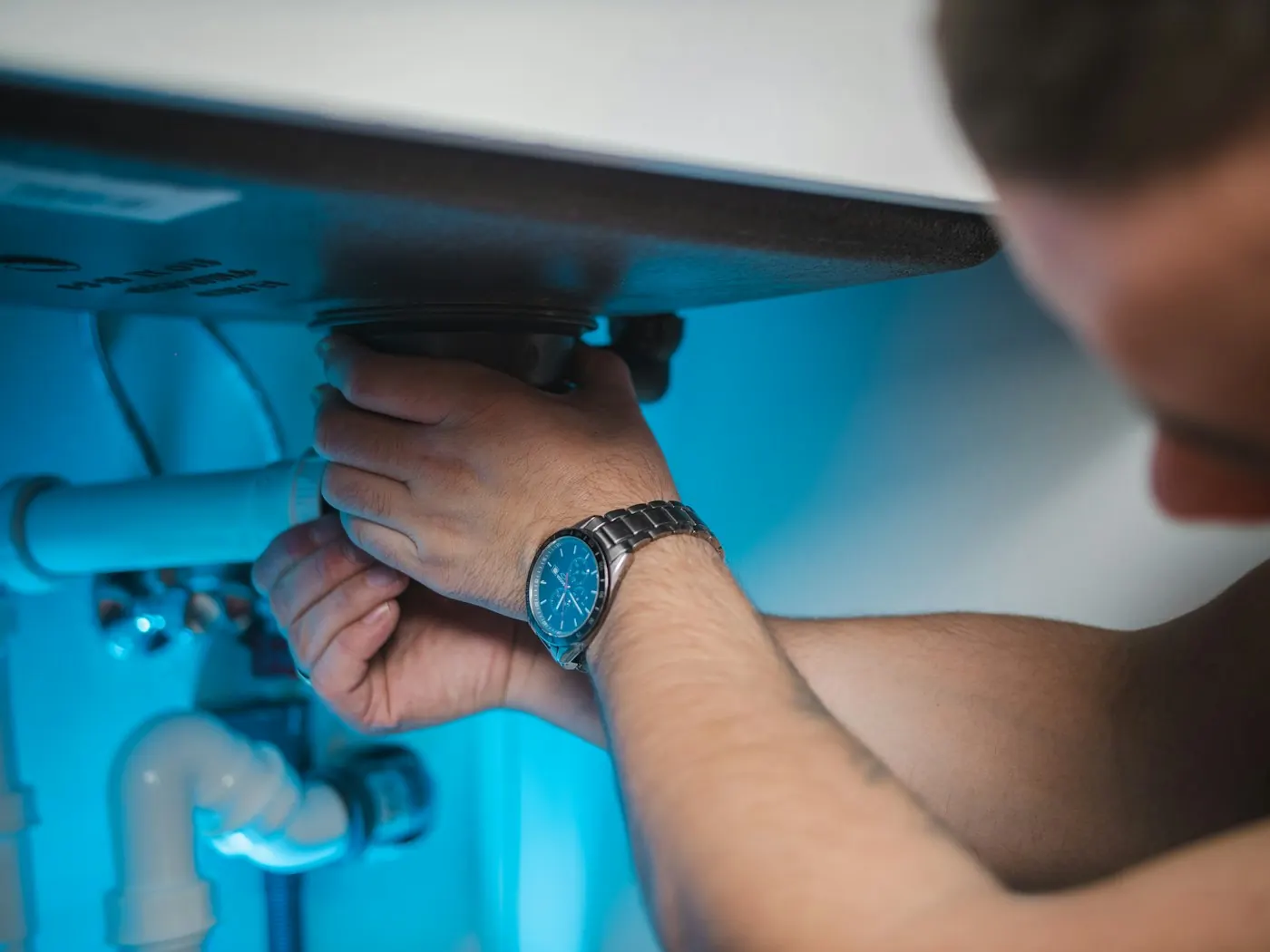 Plombier réparant un chauffe-eau électrique, contrôle des raccordements