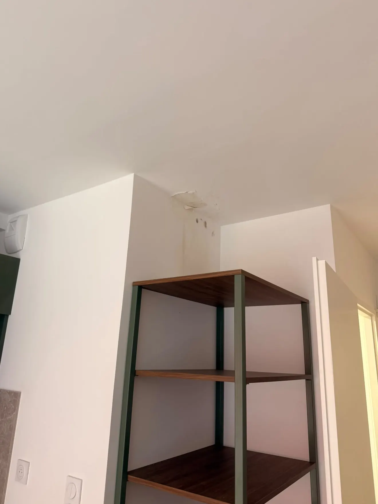 Avant : plafond et angle de mur tachés et cloqués par un dégât des eaux