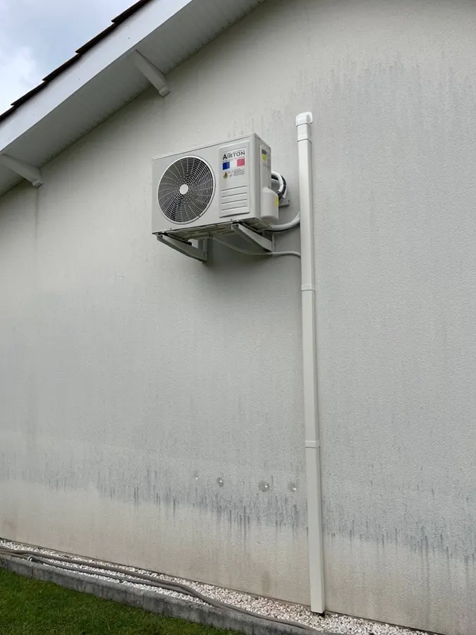 Unité extérieure de climatisation fixée en façade avec liaisons sous goulotte
